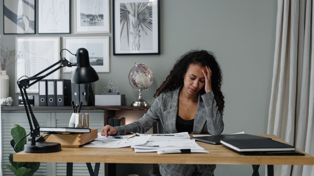 Woman experiencing anxiety, overwhelm, brain fog, and hormonal mood changes while working.
