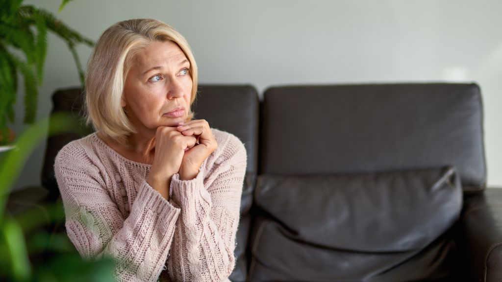Woman experiencing early signs and symptoms of perimenopause including mood changes and fatigue.