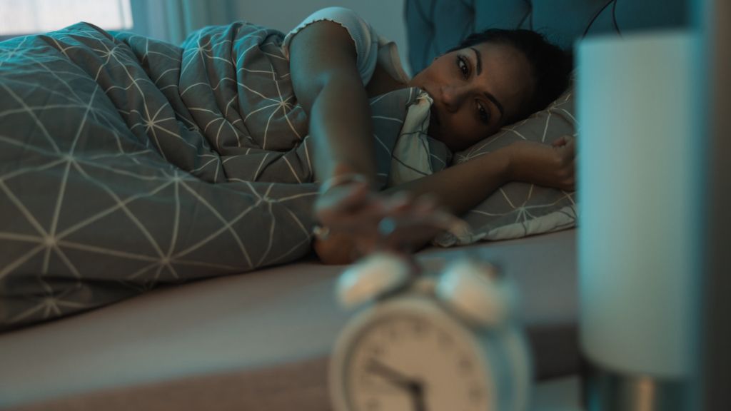 Perimenopausal woman experiencing insomnia, night waking, and sleep disruption.