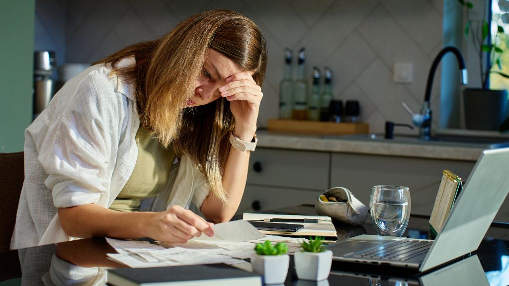 Woman reviewing normal lab results while still experiencing fatigue, anxiety, brain fog, and hormonal symptoms.